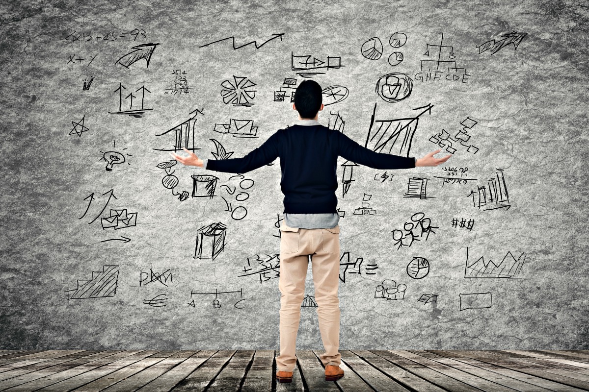 Man with disorderly business plan on wall.